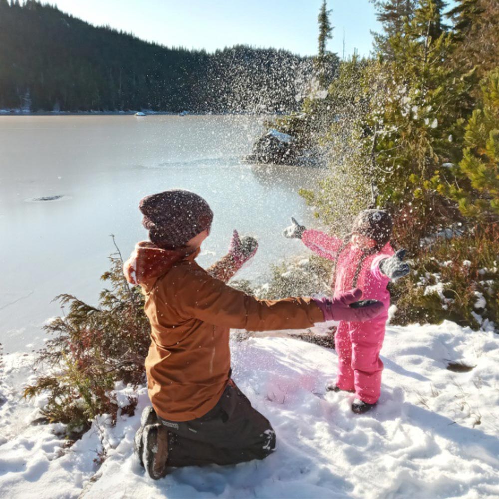 Mom and kid playing in snow.